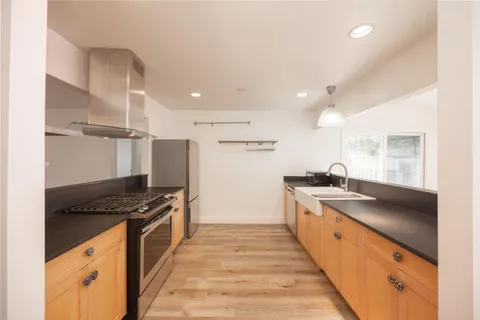 a kitchen with granite countertop a sink stove and refrigerator