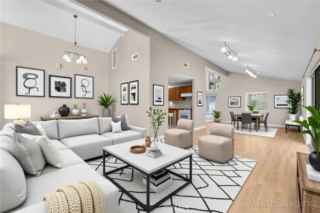 a living room with furniture potted plant and open kitchen view