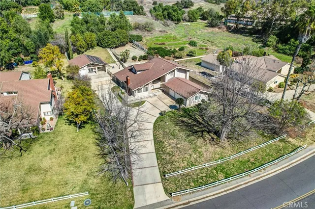 an aerial view of residential houses with outdoor space and trees