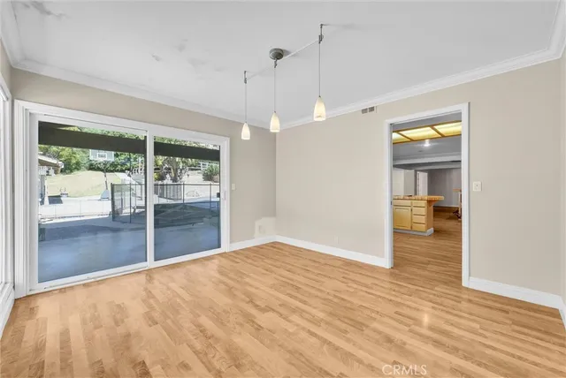 a view of empty room with wooden floor