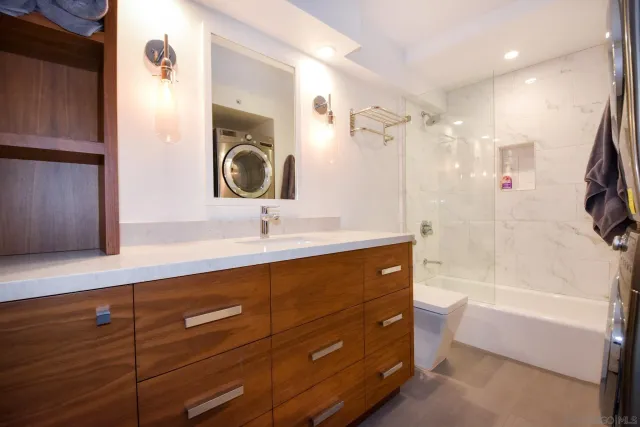 a bathroom with a sink double vanity granite tub shower and a mirror