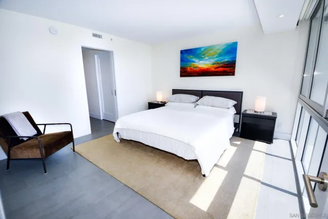 a bedroom with a bed a couch and a painting on the wall