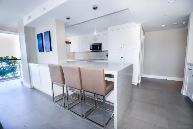 a kitchen with stainless steel appliances granite countertop a stove a sink a refrigerator and a dining table with wooden floor