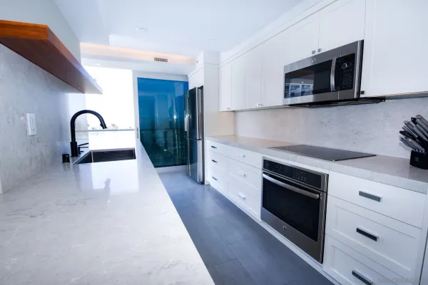 a kitchen with sink a microwave a stove and cabinets