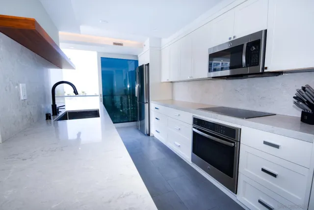 a kitchen with sink a microwave a stove and cabinets