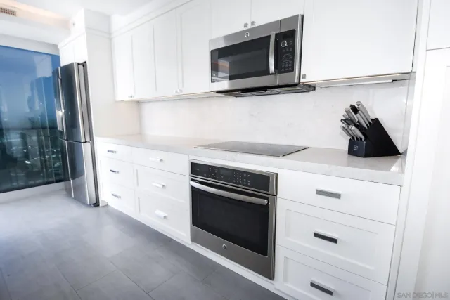 a kitchen with white cabinets and stainless steel appliances