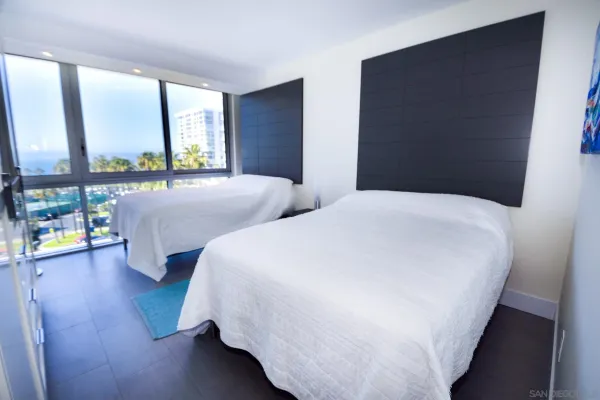 a bedroom with two beds and a large window