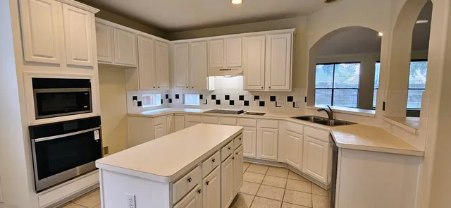 a kitchen with cabinets and chairs