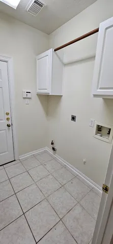a view of an empty room with wooden floor fireplace and a window