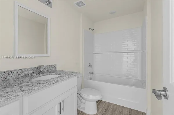 a bathroom with a sink toilet vanity and shower