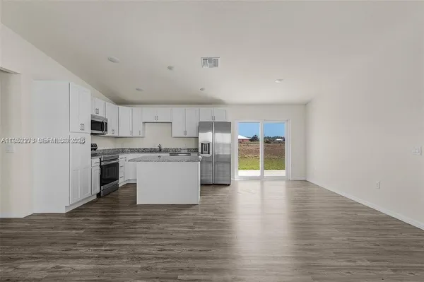 a kitchen with stainless steel appliances a refrigerator sink and cabinets