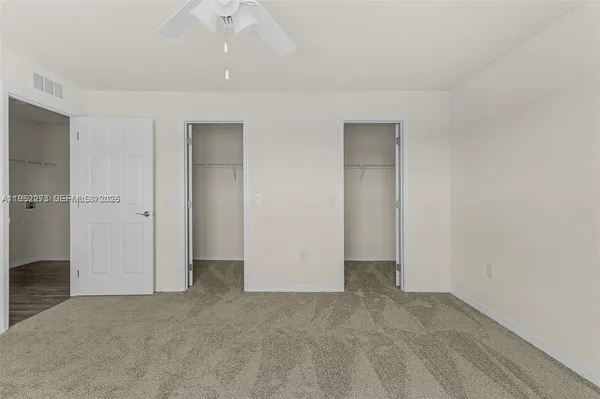 an empty room with closet and a hallway