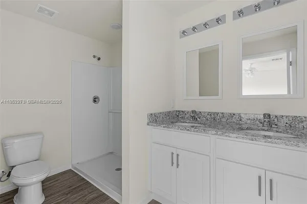 a bathroom with a granite countertop sink toilet and shower
