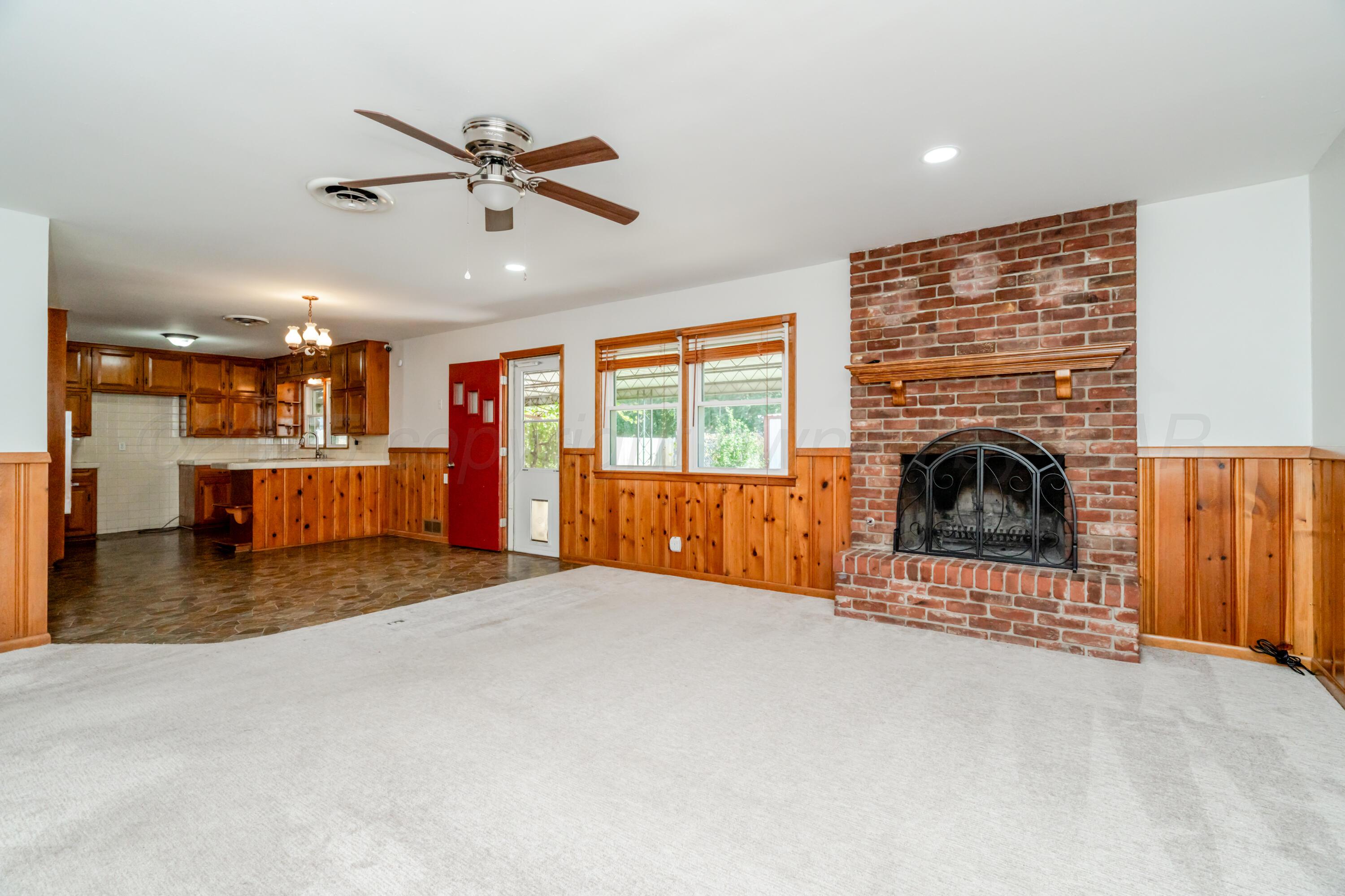 4721 Cherokee Trail Amarillo, TX 79109 - Photo 13 of 42 a view of a livingroom with a fireplace a ceiling fan and windows