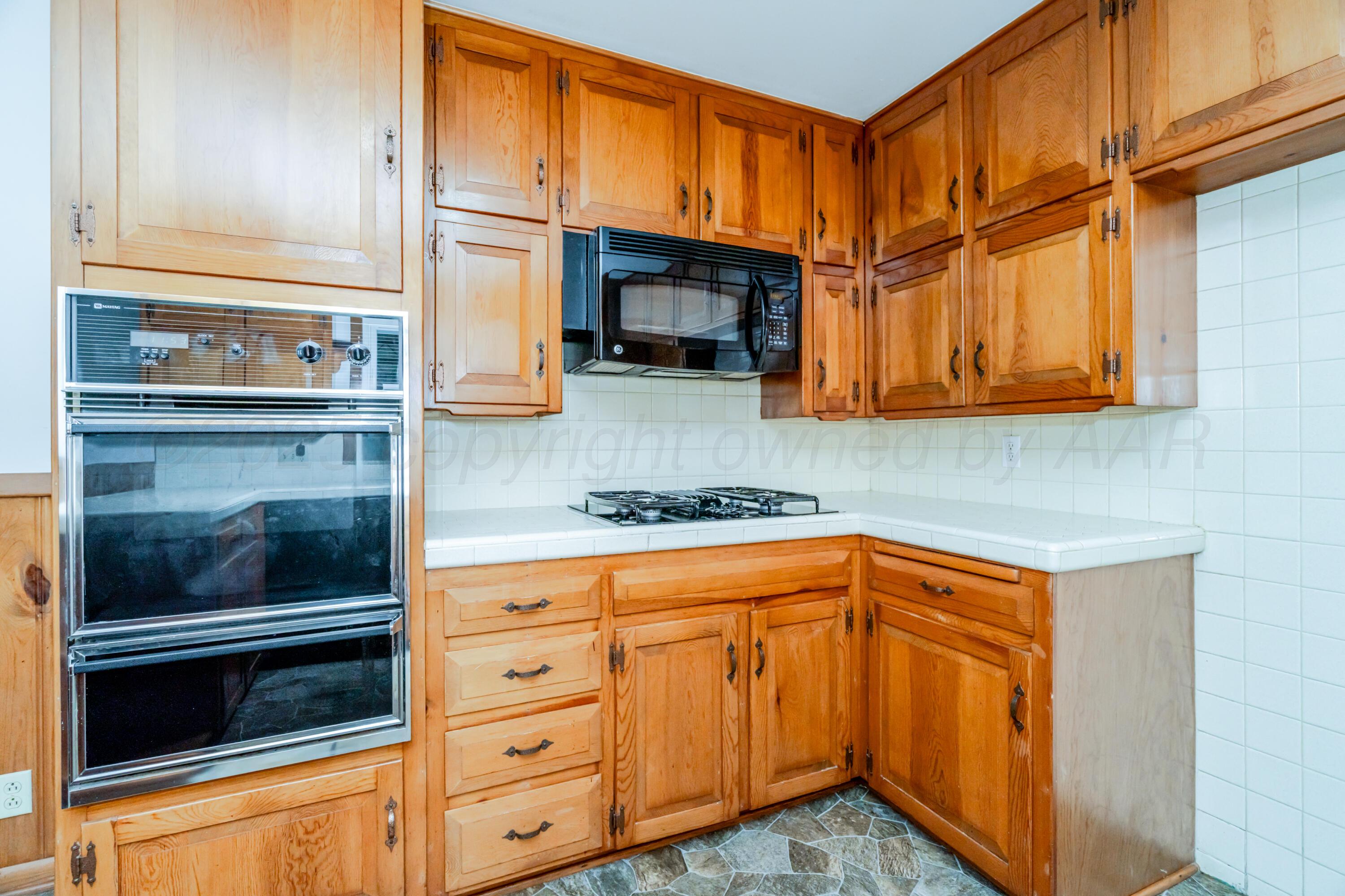 4721 Cherokee Trail Amarillo, TX 79109 - Photo 16 of 42 a kitchen with stainless steel appliances granite countertop a stove and a microwave