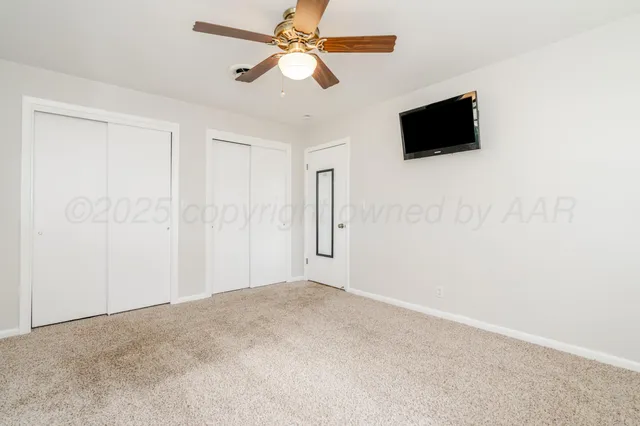 an empty room with a window and a fan