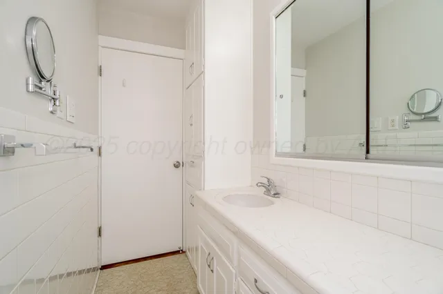 a bathroom with a granite countertop sink a mirror and a bathtub