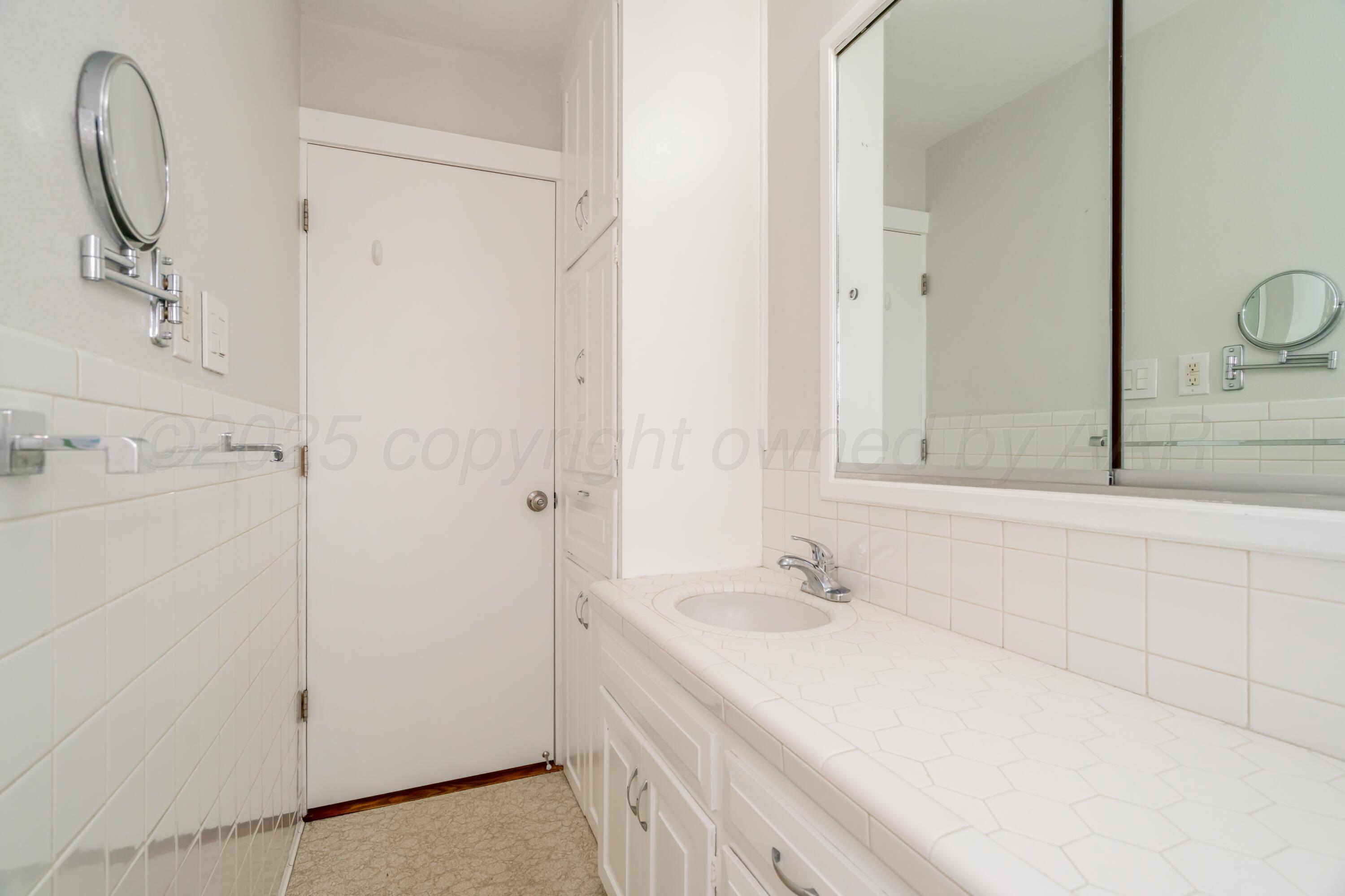 4721 Cherokee Trail Amarillo, TX 79109 - Photo 25 of 42 a bathroom with a sink and a mirror