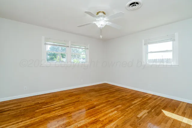 a view of a room with a ceiling fan and a window