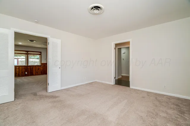 an empty room with windows and ceiling fan