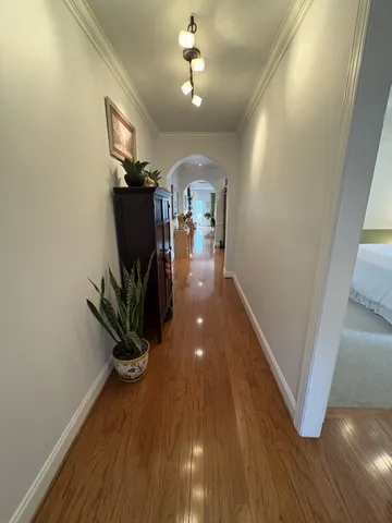 a view of a hallway with wooden floor and stairs
