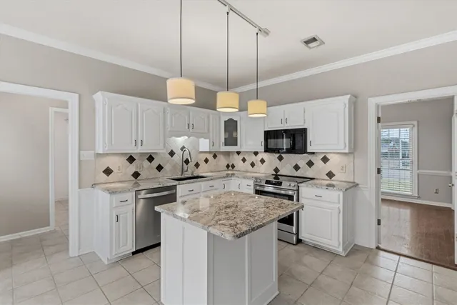 a kitchen with stainless steel appliances granite countertop a stove and a refrigerator