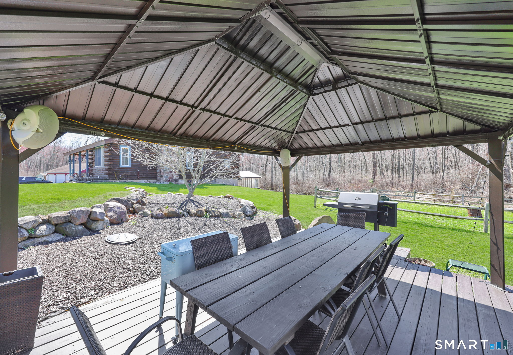 800 Gaylord Mountain Road Hamden, CT 06518 - Photo 35 of 40 a view of a patio with table and chairs under an umbrella with a wooden floor