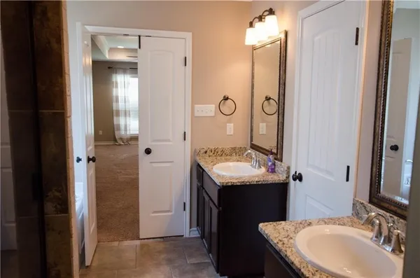 a bathroom with a granite countertop sink and a mirror