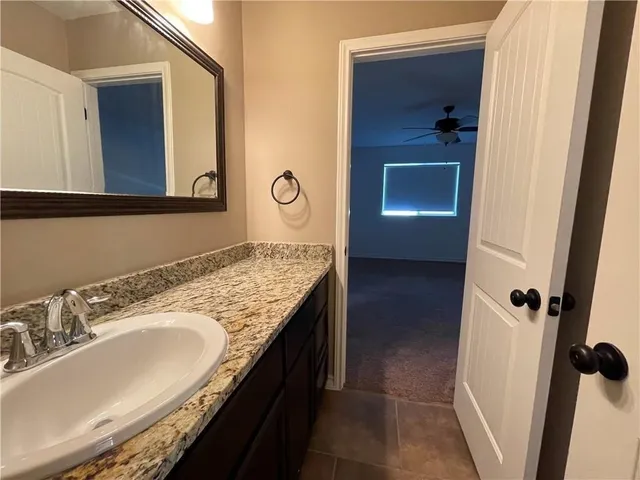 a bathroom with a granite countertop sink and mirror