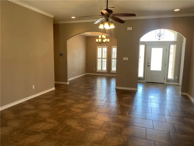 a view of a room with chandelier potted plants and wooden floor