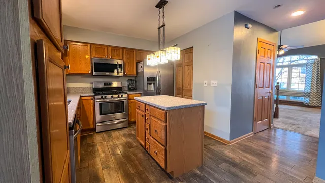 a kitchen with stainless steel appliances granite countertop a refrigerator a stove top oven a sink and dishwasher