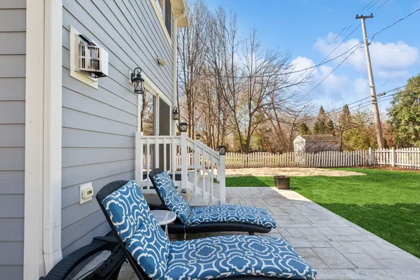 a view of a chair and tables in the backyard of the house