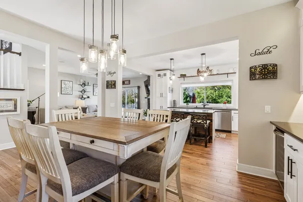 a dining room with stainless steel appliances kitchen island a table and chairs