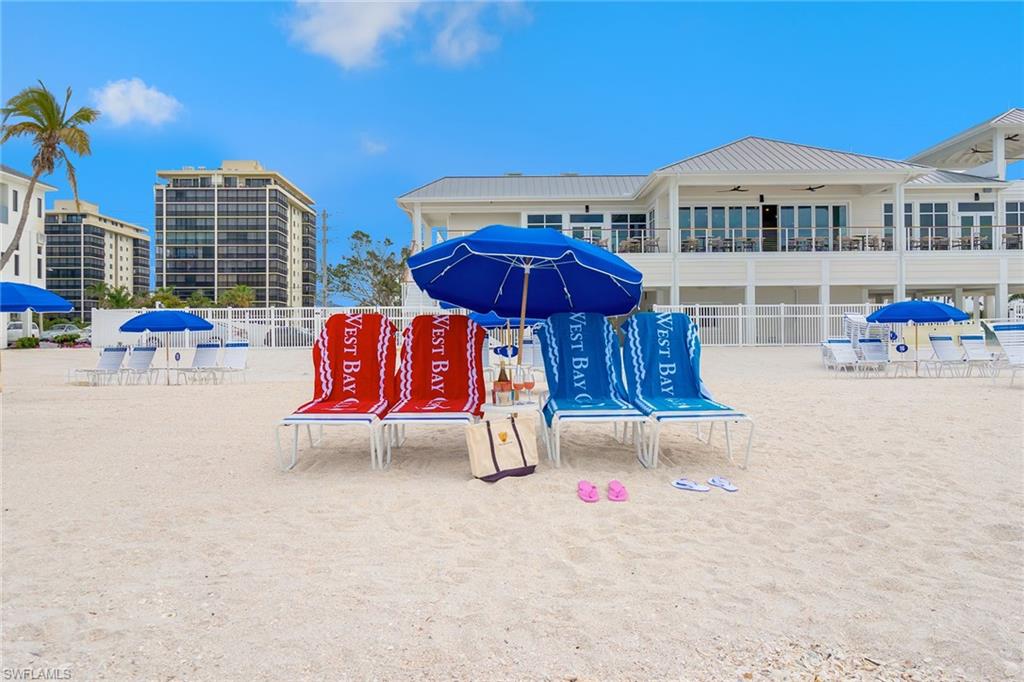 5100 Baybridge Boulevard, Unit 1704 Estero, FL 33928 - Photo 15 of 35 a view of a patio with a table and chairs under an umbrella with large trees