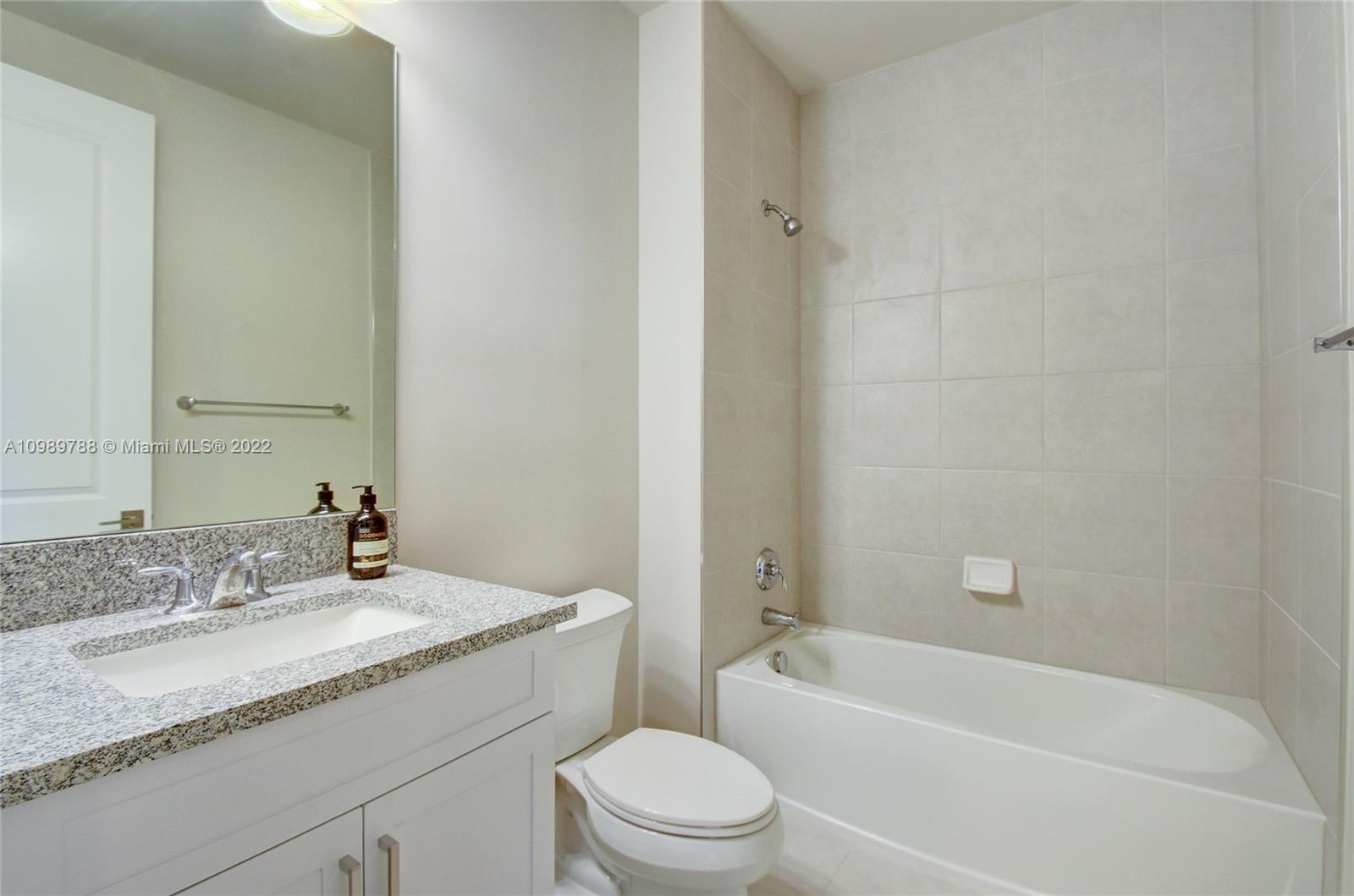 17805 Rolling Oaks Estates Dr Ranches Southwest Ranches, FL 33331 - Photo 30 of 49 a bathroom with a granite countertop sink a toilet and bathtub