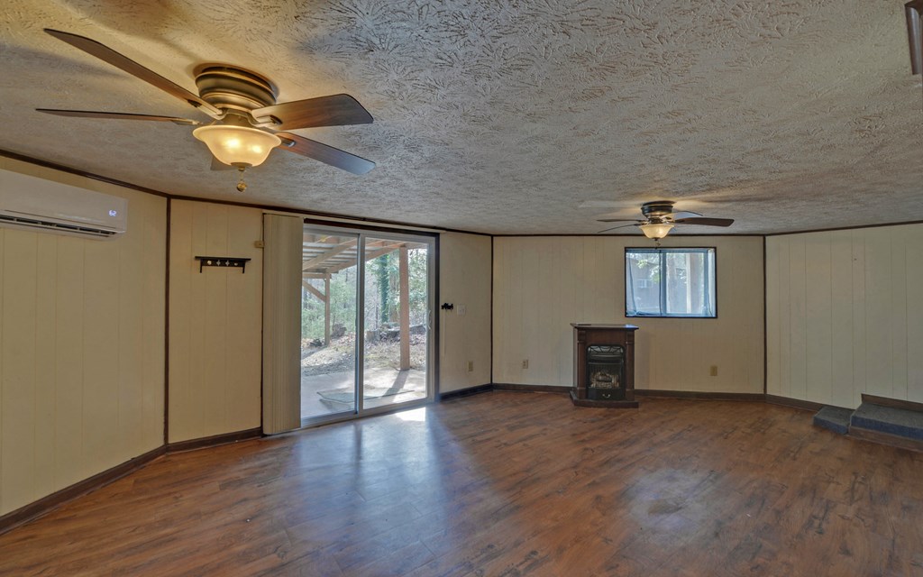 15 Trails End Road Blue Ridge, GA 30513 - Photo 20 of 46 an empty room with wooden floor a ceiling fan and windows