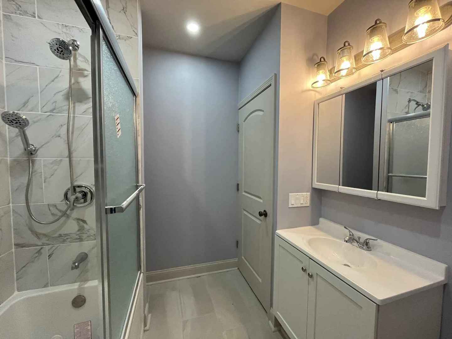 1446 West Irving Park Road, Unit 1 Chicago, IL 60613 - Photo 37 of 45 a bathroom with a shower sink and mirror