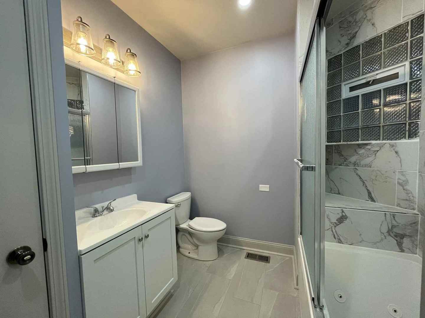 1446 West Irving Park Road, Unit 1 Chicago, IL 60613 - Photo 38 of 45 a bathroom with a sink a toilet and shower