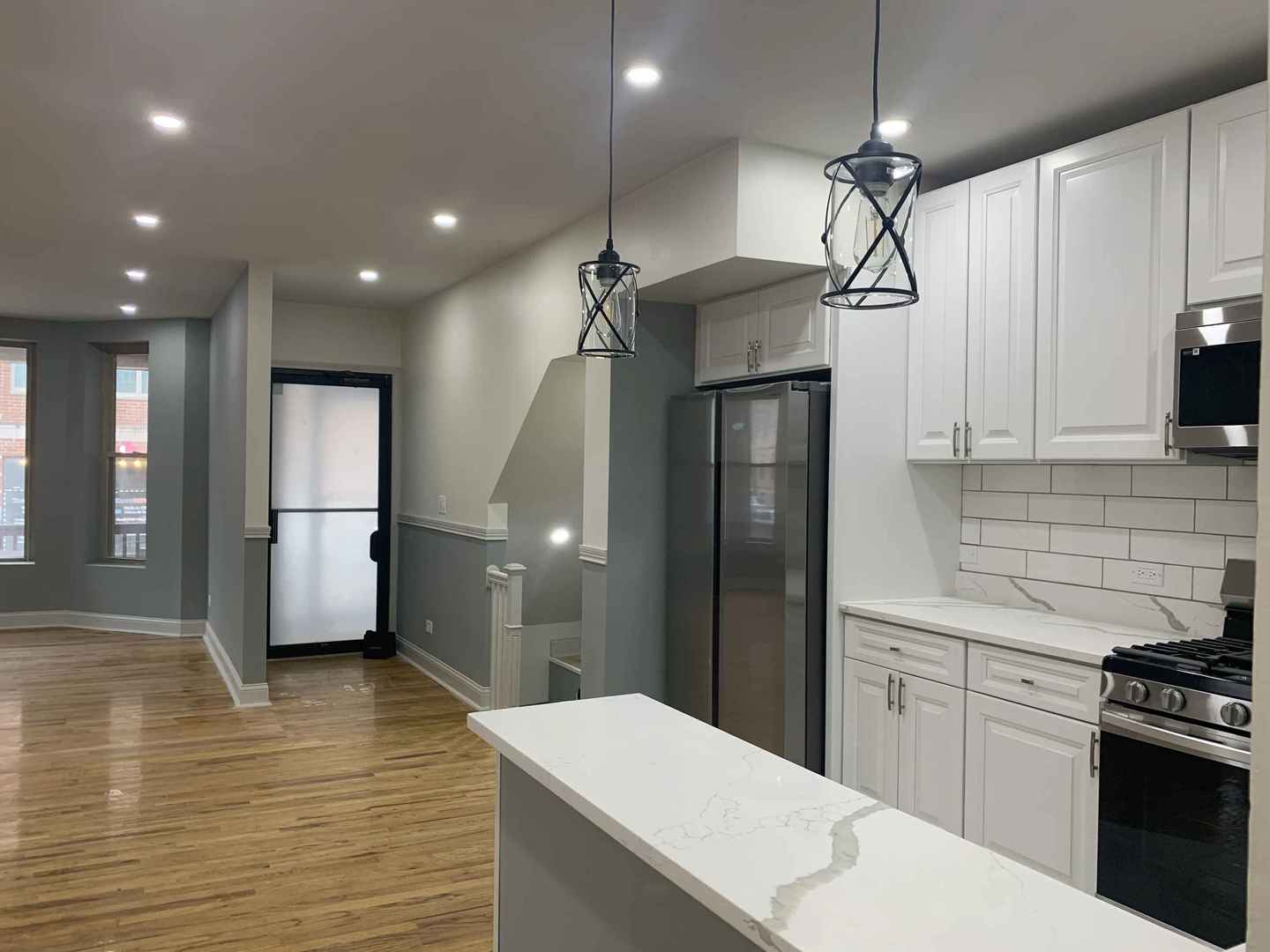 1446 West Irving Park Road, Unit 1 Chicago, IL 60613 - Photo 5 of 45 a kitchen with stainless steel appliances kitchen island a refrigerator sink and cabinets