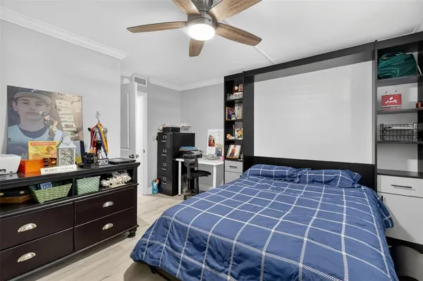 a bedroom with a bed and a flat tv screen on dresser