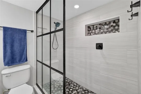 a bathroom with a shower toilet and a window