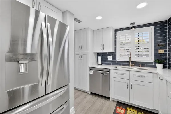 a kitchen with stainless steel appliances a refrigerator sink and cabinets