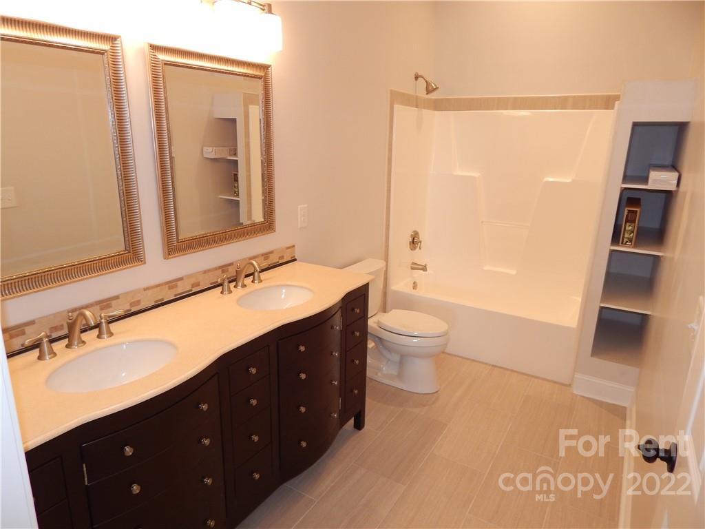 5312 Davis Road, Unit A Waxhaw, NC 28173 - Photo 3 of 12 a spacious bathroom with a double vanity sink toilet and shower