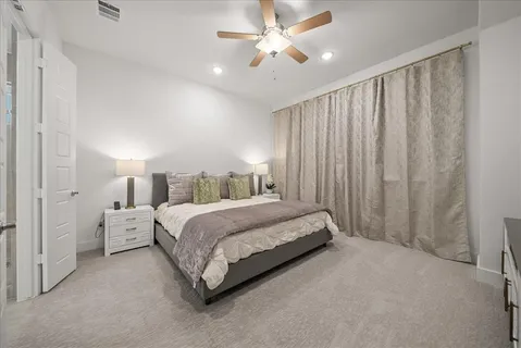 a spacious bedroom with a bed and a chandelier