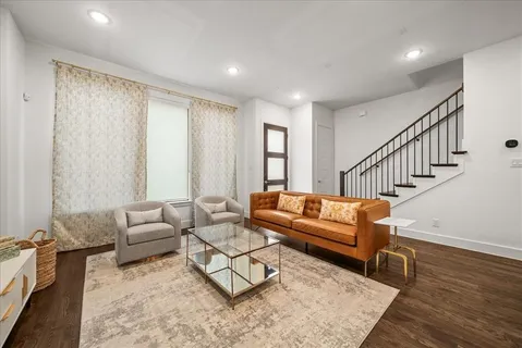 a living room with furniture and wooden floor