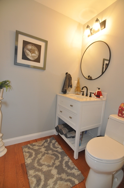 47 Maple Street, Unit A Middleton, MA 01949 - Photo 18 of 29 a bathroom with a toilet mirror vanity and a sink