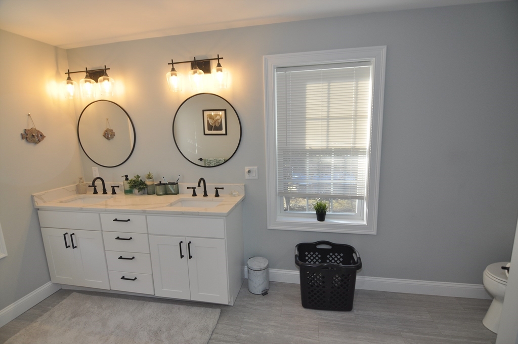 47 Maple Street, Unit A Middleton, MA 01949 - Photo 20 of 29 a bathroom with a toilet a sink and a large mirror