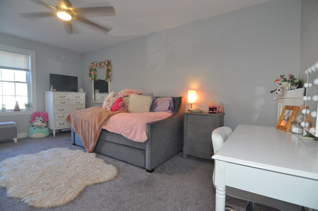 47 Maple Street, Unit A Middleton, MA 01949 - Photo 26 of 29 a bedroom with a bed and a chandelier