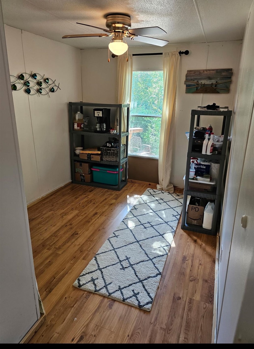 390 Wharf Road Savannah, TN 38372 - Photo 12 of 17 Room featuring wood-finish flooring, a ceiling fan with integrated lighting, and a window with sheer drapes