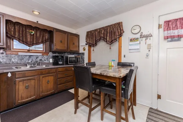a kitchen with granite countertop a table chairs a sink and cabinets